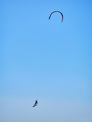 A young man practicing Kitesurf at backlight.