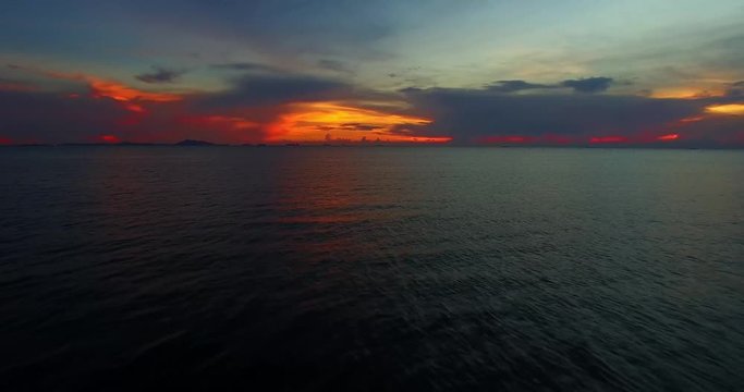 Aerial footage from Drone. dramatic sunrise over the ocean with clouds, highlighted from the down by the rising sun. footage 4K