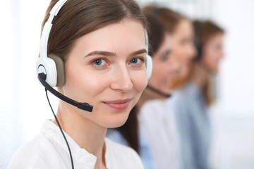 Call center. Beautiful cheerful smiling operator consulting clients with headset. Business concept...