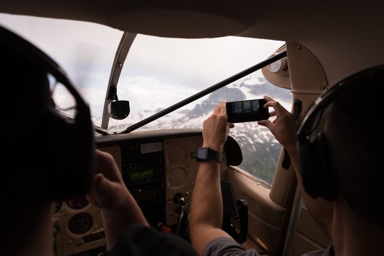 Pilot taking photos with mobile phone while flying