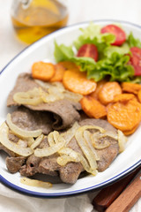 fried liver with onion, sweet potato and salad  on white dish