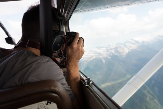Pilot taking photos with camera while flying