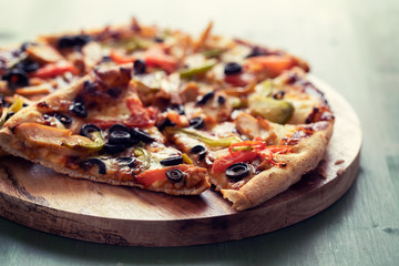 pizza with chicken and olives on green wooden background