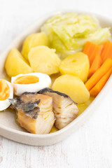 cod fish with boiled egg and vegetables on dish