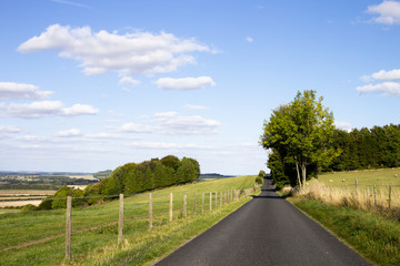 Fototapeta na wymiar Single lane country road through countryside and farmland
