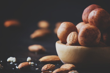 Marzipan, round almond candies in wooden bowl on dark table, selective focus
