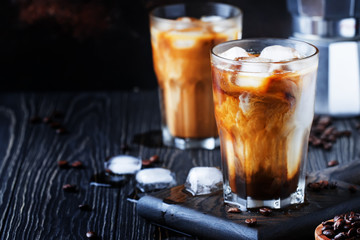 Coffee with ice and milk, brown table, selective focus and shallow DOF - obrazy, fototapety, plakaty