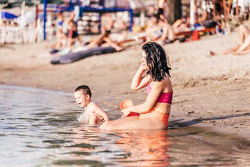 Happy mother and son playing on beach