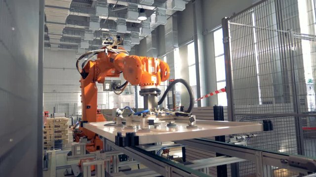 Modern factory robotic arm working at a plant. 4K.