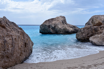 Fototapeta na wymiar BLUE SEA AND ROCKS ON THE BEACH
