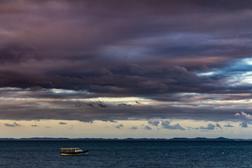 storm on the sea in the vicinity of the coast where a small boat is anchored