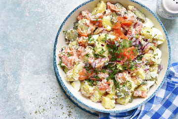 New potato salad with salted salmon, pickled cucumber, egg, capers and red onion.Top view.
