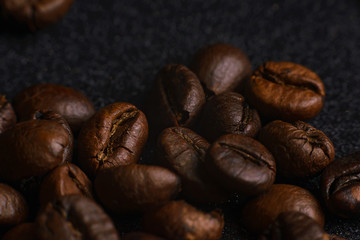 Texture of roasted coffee beans on dark background. Macro image