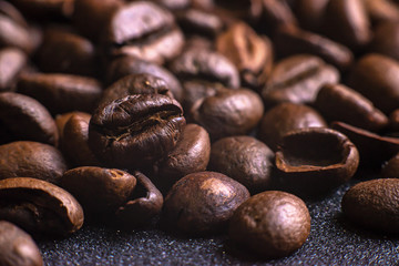 Texture of roasted coffee beans on dark background. Macro image