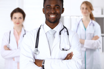 Happy african american male doctor  with medical staff at the hospital. Medicine concept