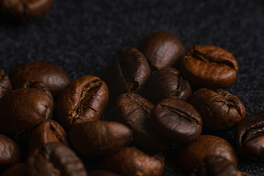 Texture of roasted coffee beans on dark background. Macro image © Maryana