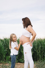 Little Girl with her pregnant mother in the field