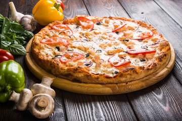 Italian pizza. Creative author's pizza with tomatoes, olives and fish