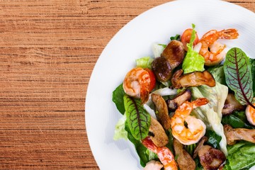 Green salad with shrimps on background