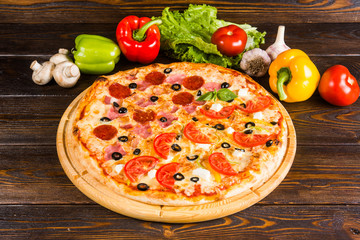 2 kinds of pizza in one - salami, tomatoes, ham. Creative author's pizza.