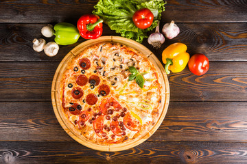 4 kinds of pizza in one - salami, bacon, tomatoes, ham. Creative author's pizza home made.