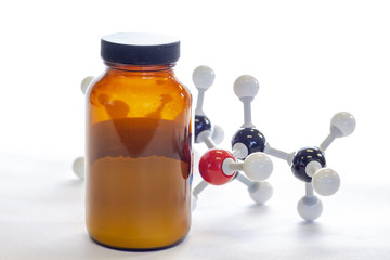 Brown bottle containing a powder with a chemical structure in the background.