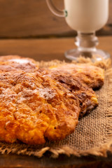 Round homemade cookies with milk, close-up, vertical frame on wooden background.