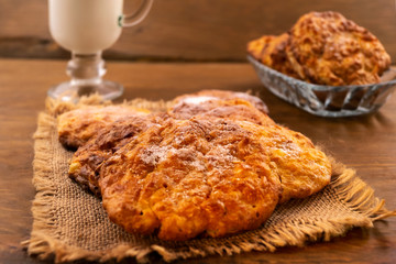 Dessert of cookies with powdered sugar powder, laid on a linen napkin, wooden background.