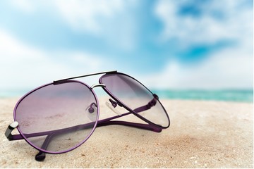 Fototapeta na wymiar Sunglasses on sandy beach background