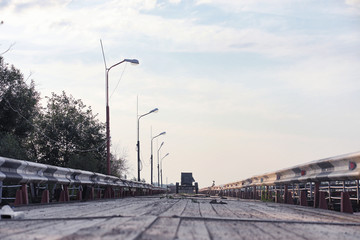 Naklejka premium Wooden bridge on the river bank. A wooden road with pillars. Pan