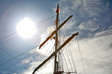 Obraz premium masts of the sailboat on the background of the sun