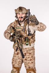 Portrait soldier or private military contractor making stop sign with black pistol. war, army, weapon, technology and people concept. Image on a white background.