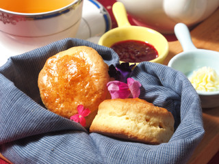 Close up of delicious  scones with  jam,  cream and cup of tea.