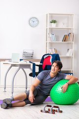 Young male employee exercising in the office