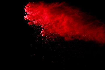 Abstract of red powder explosion on black background. Red powder splatted isolate. Colored cloud....