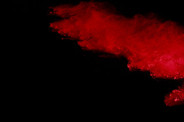 Abstract of red powder explosion on black background. Red powder splatted isolate. Colored cloud....