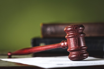 Wooden gavel and books on wooden table, law concept