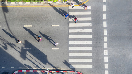people crowd walk in top view at street city with pedestrian crosswalk in traffic road with light and shadow silhouette