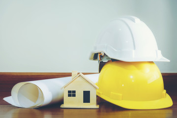 White and yellow helmet with wooden houses and various devices that are placed on a wooden floor.