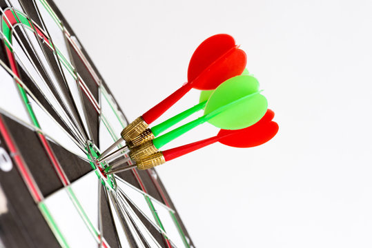 Close up shot green and red darts arrows in the target center. Business target or goal success and winner concept.