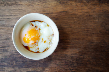Onsen tamago egg or soft-boiled egg in traditional Japanese served with paper and shoyu soy sauce, copy space