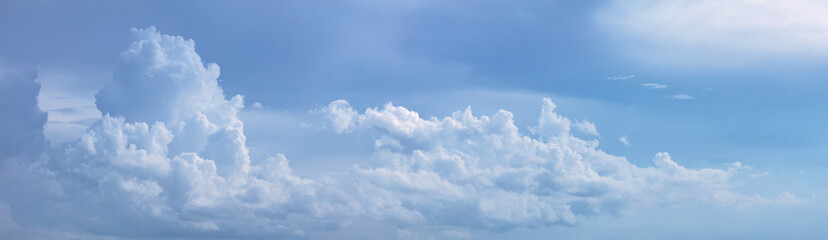 Naklejka na ściany i meble powerful clouds move across a blue sky panorama
