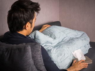 Man on sick bed with tissue paper and blanket