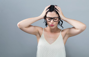 Young woman feeling stressed on a solid background