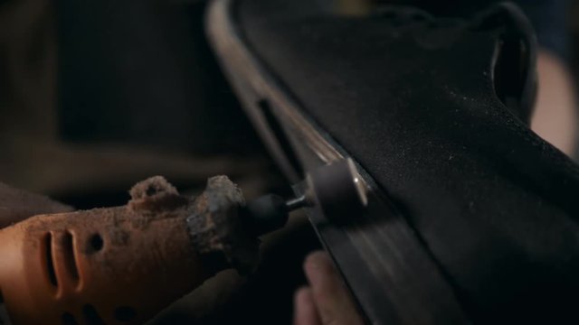 shoemaker makes shoes for men He polishes sole of shoe handmade craft production factory leather boots