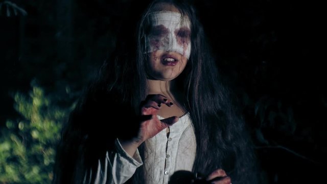 A walk through the night forest - a zombie-undead girl, obsessed with evil attacks on the camera