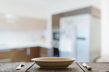 empty plate with fork and knife on wooden table