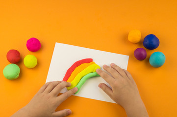child mold from colored plasticine.Children's hand