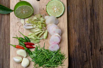 Galanga, Lemon Grass, Kaffir lime leaf, Shallot, pepper, lemon, garlic on a wooden floor. Thai Spices Cooking.