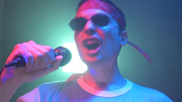 80's rock pop singer singing on a stage live giving a performance dressed like a typical 80's 90's  rockstar.